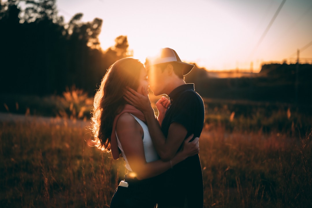 a man and a woman holding hands walking down a sidewalk